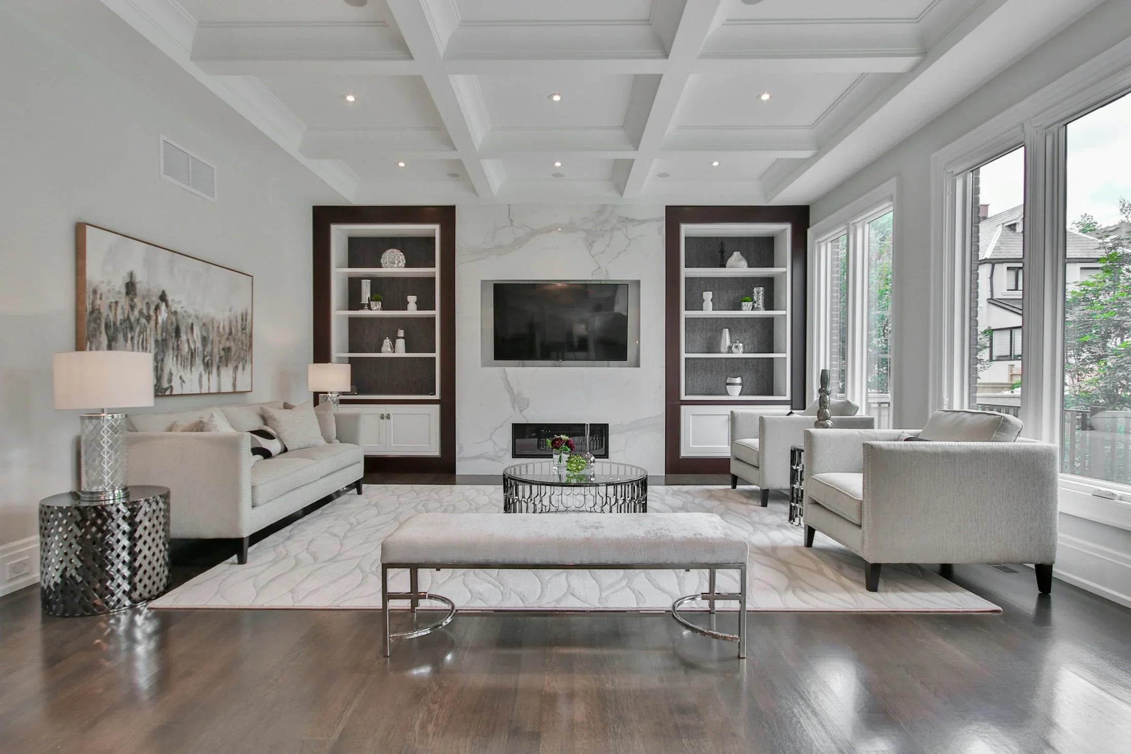A spacious living room with a marble fireplace and custom built-in shelving